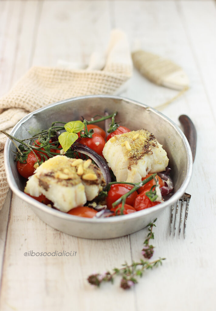 Merluzzo in crosta di olive e pinoli con cipolle rosse e pomodori
